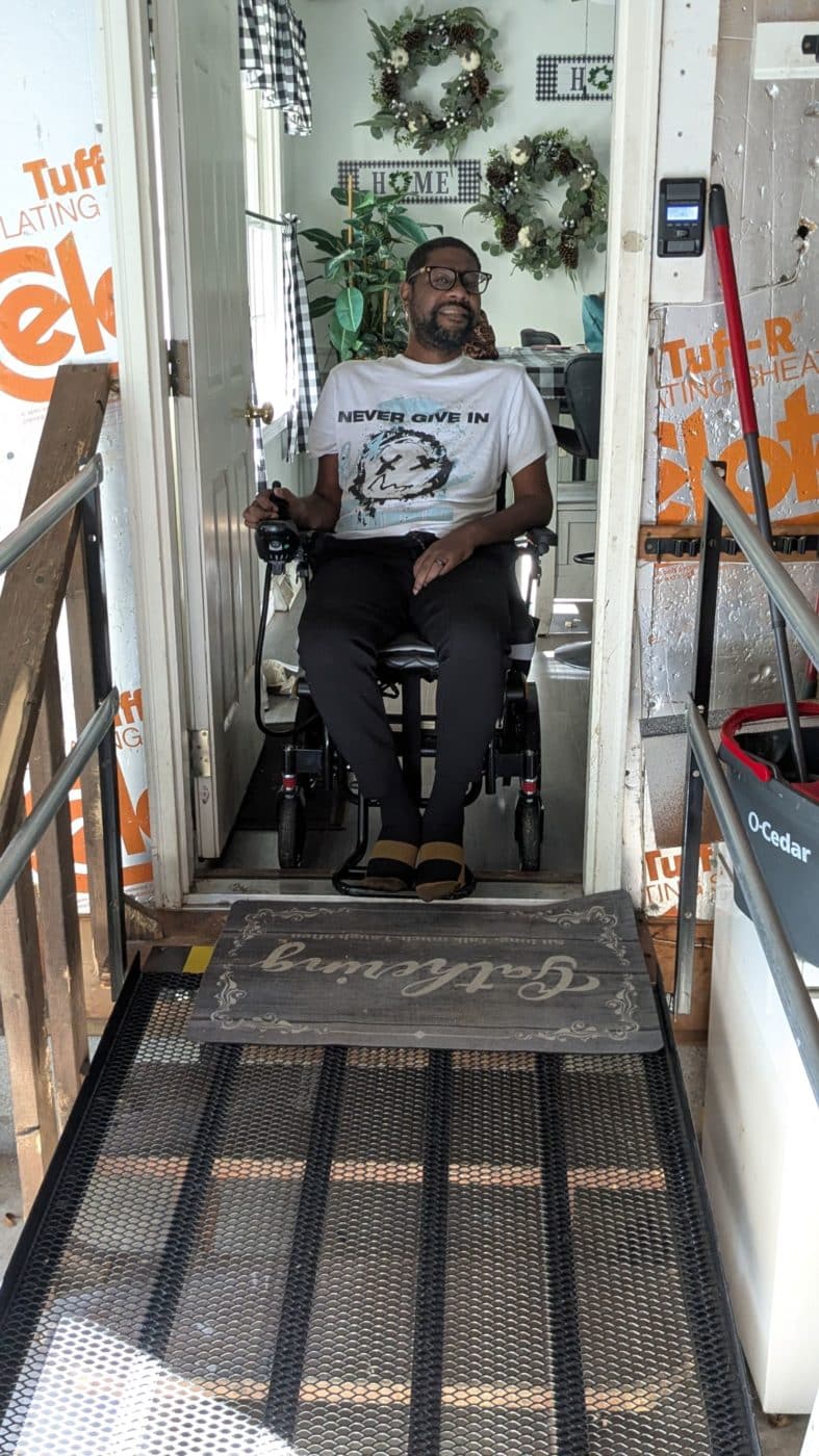 Person living with ALS using an in-home ramp.