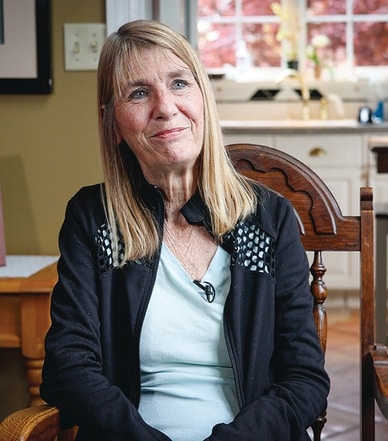 Woman sitting in a chair smiling.