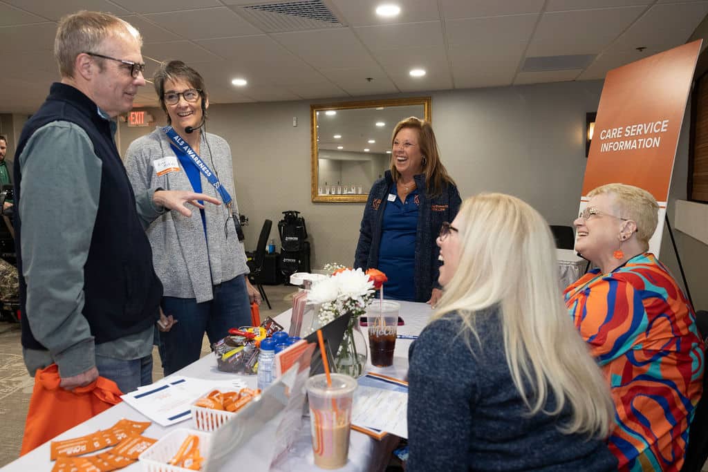 Participants of the 2026 Help and Hope Symposium talk with ALS United Mid-Atlantic care team.
